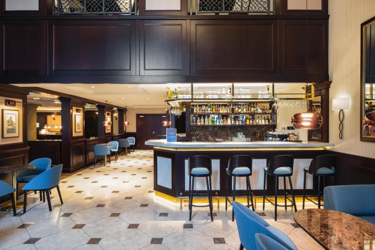 فندق راديسون بلو، غدانسك المظهر الخارجي الصورة The photo shows the interior of a bar or restaurant. It features a sleek, modern design with dark wood paneling and elegant lighting. In the center, there is a well-lit bar with a variety of bottles displayed on shelves behind it. The bar has a curve