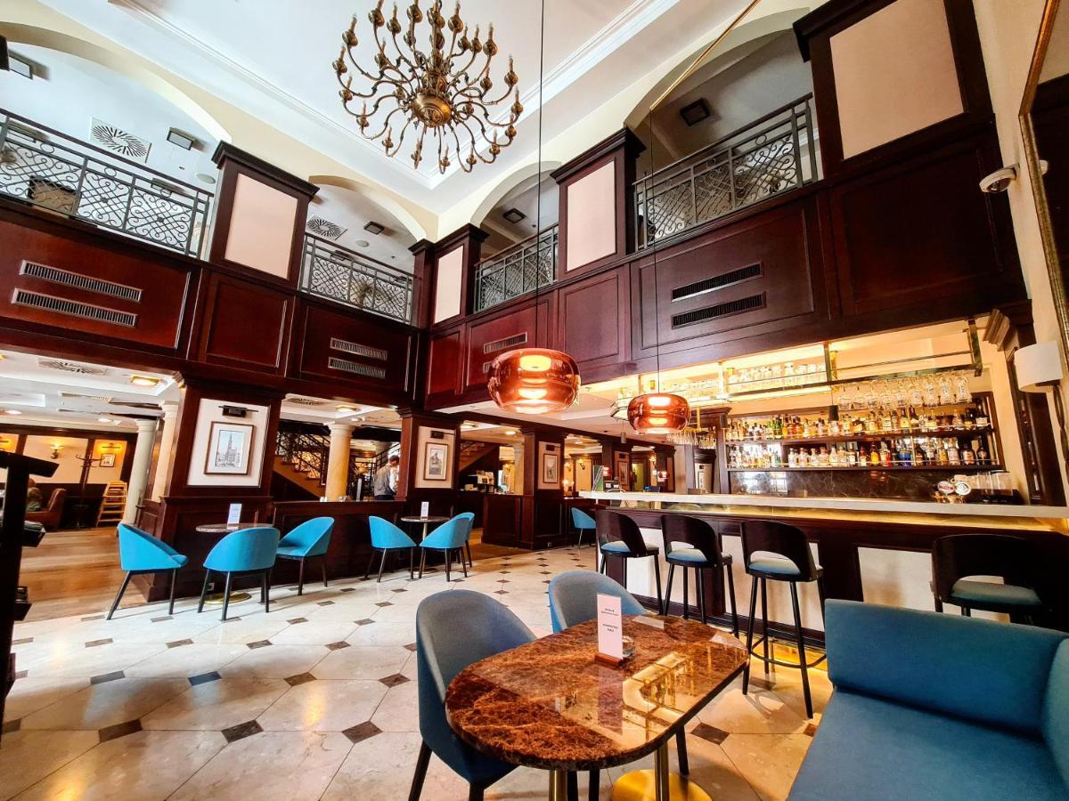 فندق راديسون بلو، غدانسك المظهر الخارجي الصورة The photo depicts an elegant interior of a bar or restaurant. It features a high ceiling with a decorative chandelier and wooden paneling, creating a sophisticated atmosphere. The space is well-lit, with a long bar counter visible in the background, 