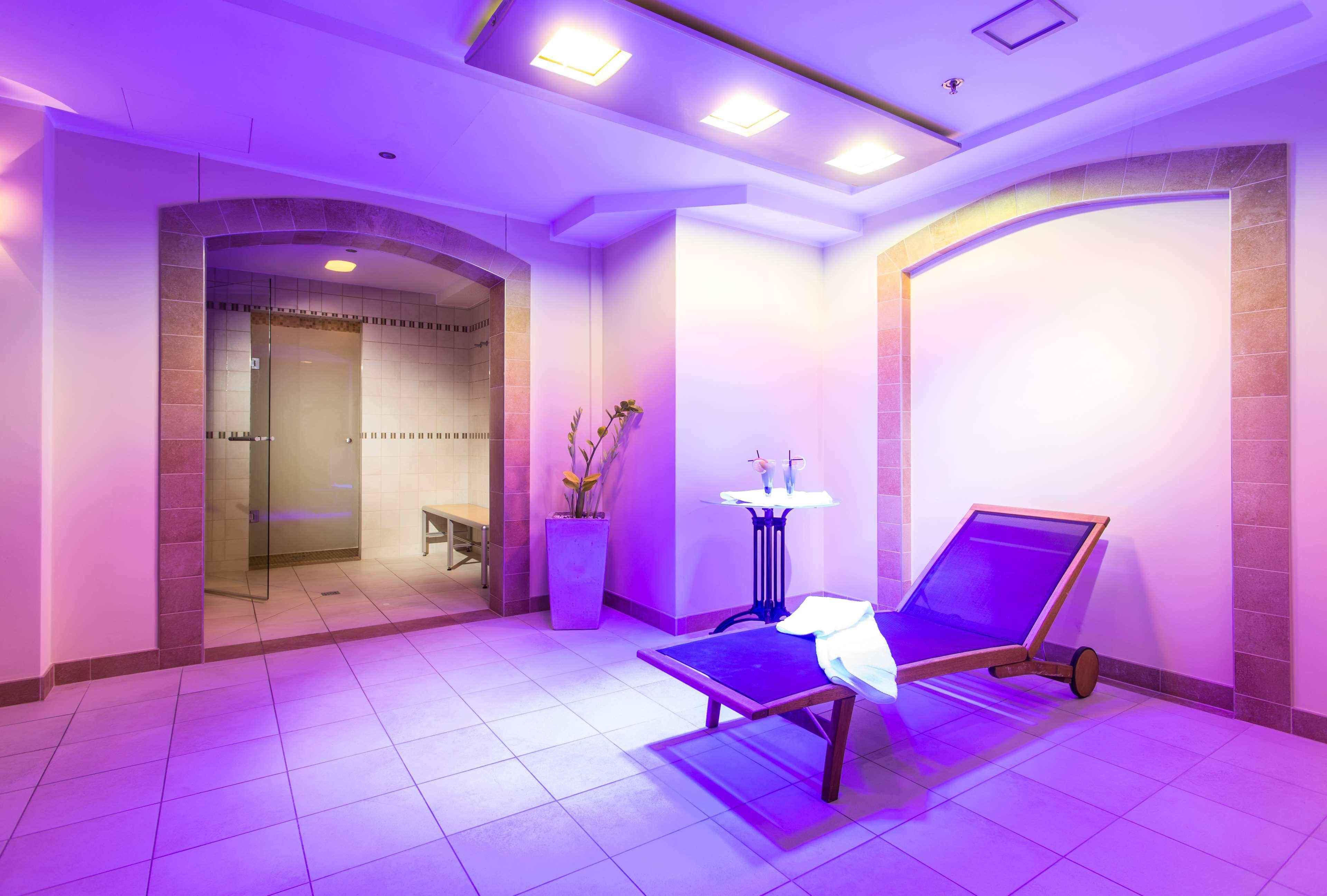 فندق راديسون بلو، غدانسك المظهر الخارجي الصورة The photo shows a serene spa-like environment. There is a long, reclining lounge chair positioned in a softly lit area, with purple lighting creating a calming ambiance. Nearby, a small table holds two glasses, suggesting a place for relaxation. On t