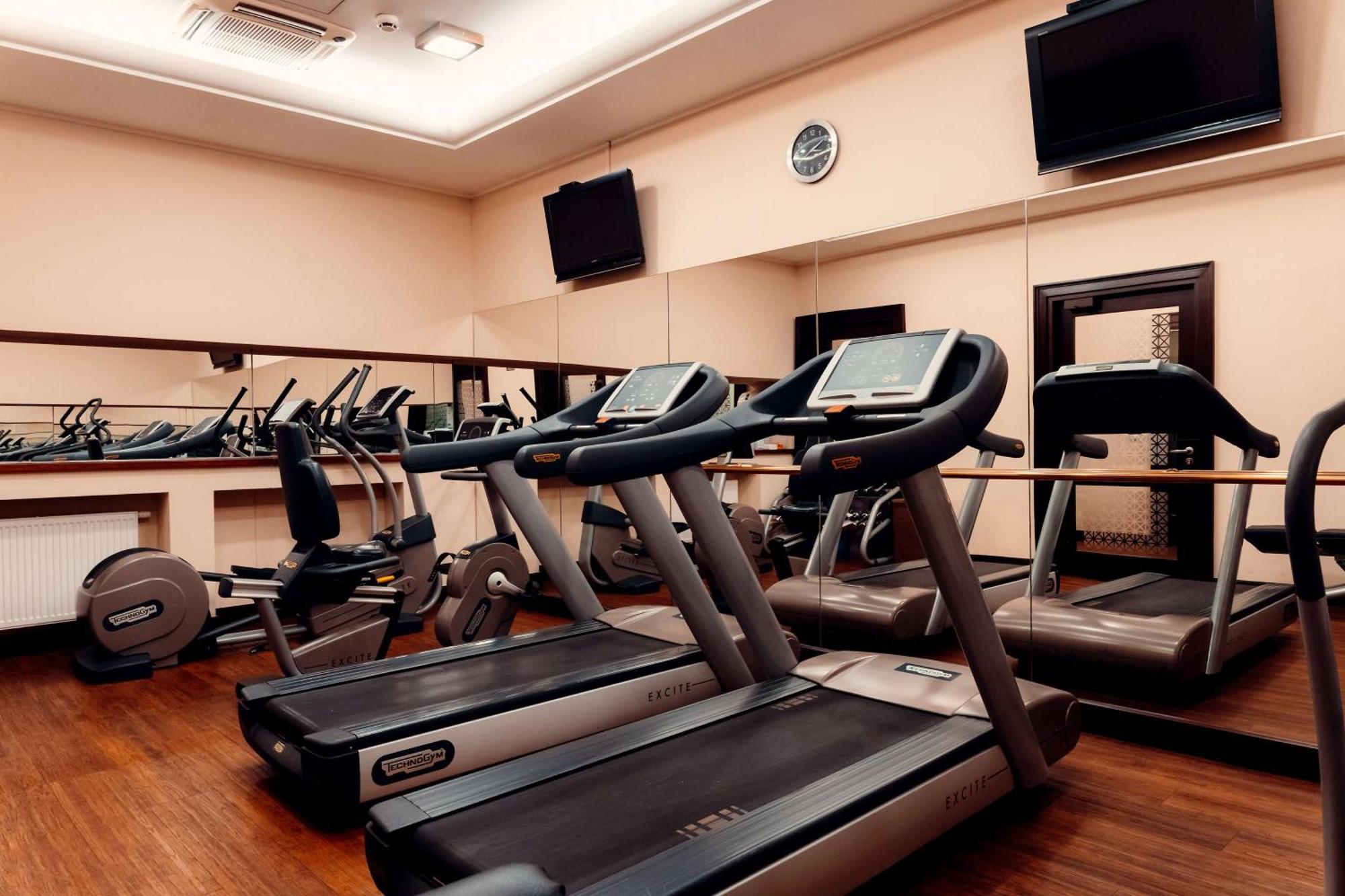 فندق راديسون بلو، غدانسك المظهر الخارجي الصورة The photo shows a gym or fitness center with several exercise machines. There are multiple treadmills lined up in the foreground, each equipped with a display screen. In the background, there are additional fitness machines, including stationary bike